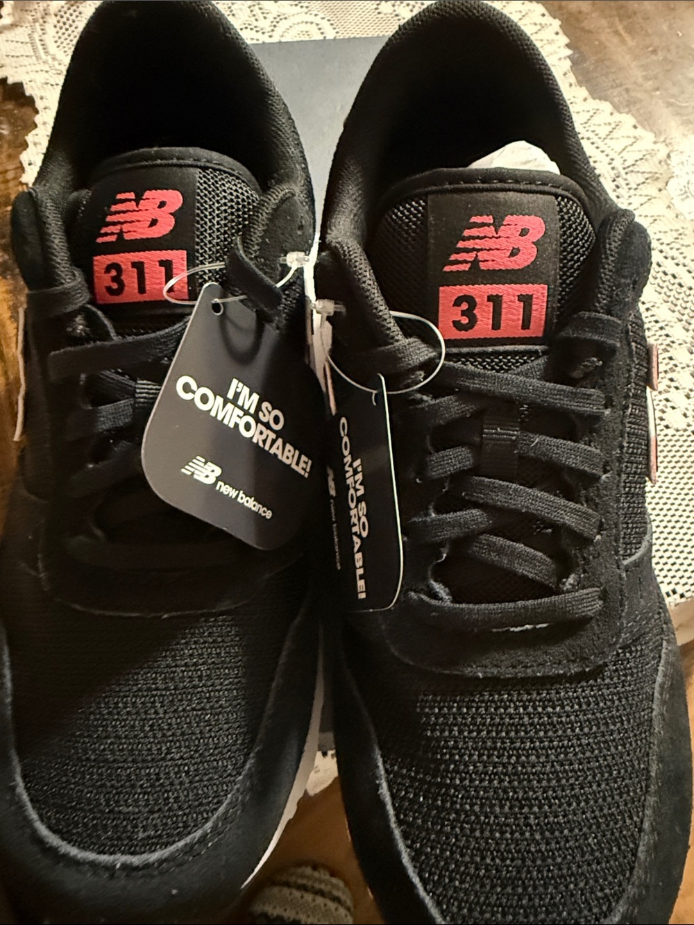 New Balance 311 woman’s Black Athletic Sneakers with orange Logo Accents